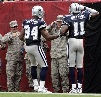 Cowboys'  wide   receiver   Roy  Williams   (11)  salutes  members  of  the  US  military  in  attendance  at  the  game.   Williams   would  be his  team's  most   potent  offensive   weapon  on the  day-hauling   4  receptions  for  135  yards  and  a  touchdown.   The   Cowboys  would   go  on to  defeat the  Buccaneers   34-21    in  the  game  played  at  Raymond  James   Stadium  ,  Tampa  ,  Fl,.   picture  appears  courtesy  of   ap/photo/  Reinhold  Matay  ................. 