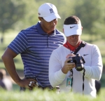 Tiger Woods, left, and his swing coach Sean Foley watch Tiger's swing video after his tee shot on the fifth hole of a Pro Am round at the 2010 BMW Championship golf tournament in Lemont, Ill., Wednesday, Sept. 8, 2010. AP / Nam Y Suh .........